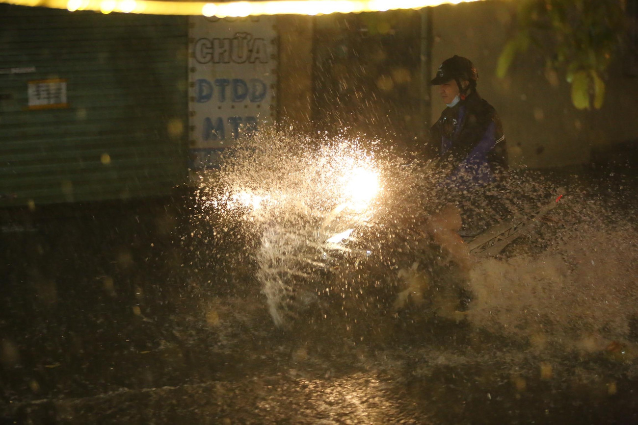 Xe máy "rẽ sóng" dưới cơn mưa lớn.