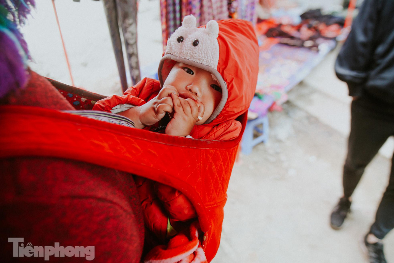 “Đi chợ trên lưng mẹ” để hòa mình vào dòng người đông đúc với cảnh mua bán chen chúc tấp nập.