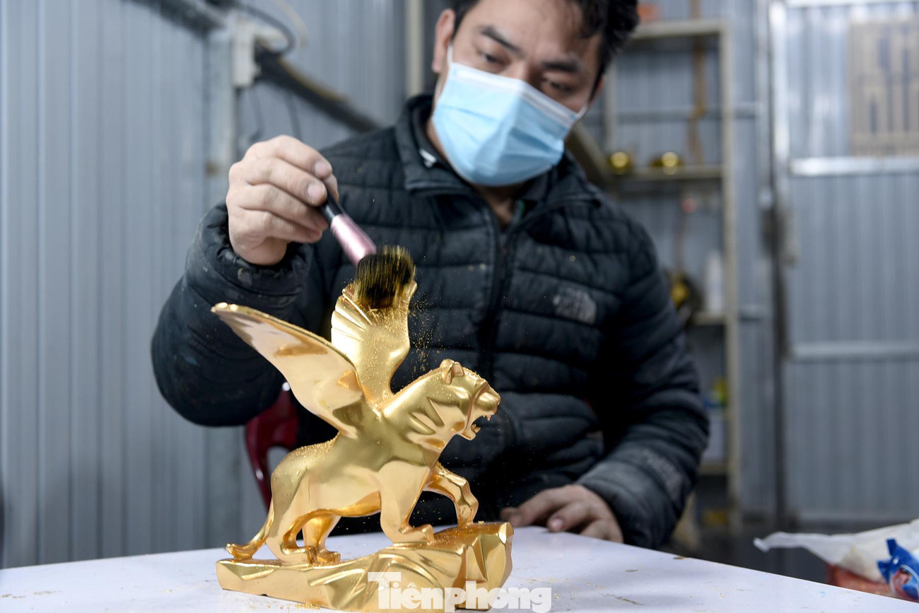 Sau đó, với những lá vàng 24k, người thợ sẽ thực hiện phủ vàng lên thân tượng