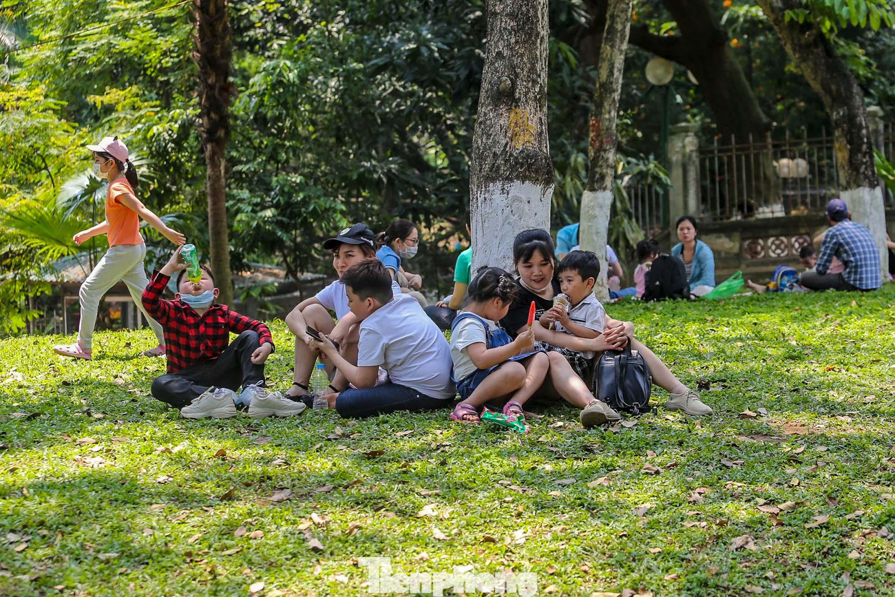 Thảm cỏ xanh trở thành chỗ ngồi nghỉ, ăn uống của các gia đình mặc dù có biển cấm.