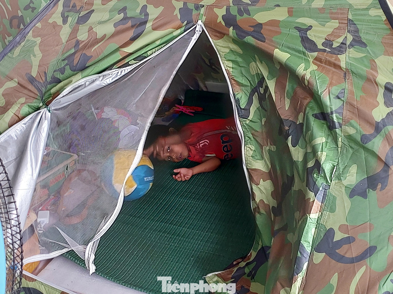 Một em bé đang chơi đùa trong lều. Cậu khá thích thú khi được chụp ảnh. Một em bé đang chơi đùa trong lều. Cậu khá thích thú khi được chụp ảnh.