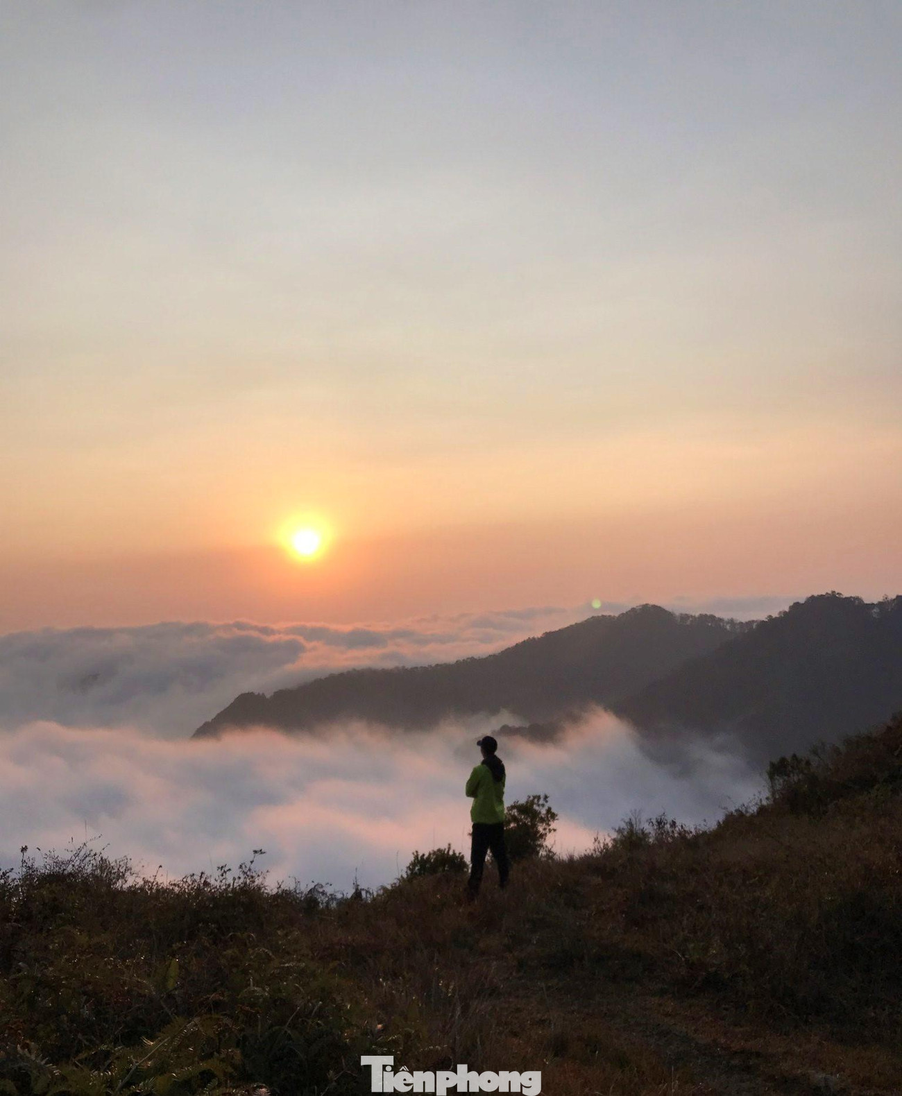 Ánh mặt trời trải dài trước những biển mây khổng lồ nằm bất động trên đỉnh núi.