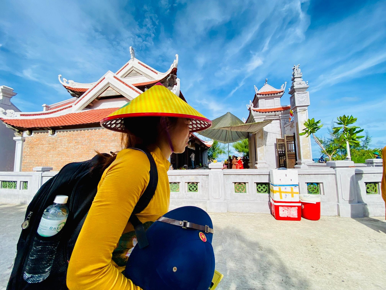 Một nữ thành viên đoàn công tác đi ngang qua Chùa Sinh Tồn Đông Một nữ thành viên đoàn công tác đi ngang qua Chùa Sinh Tồn Đông