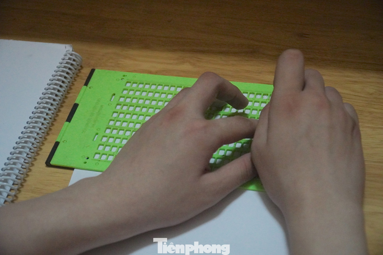 Khánh viết chữ Braille (chữ nổi) trên giấy mỗi khi học bài.