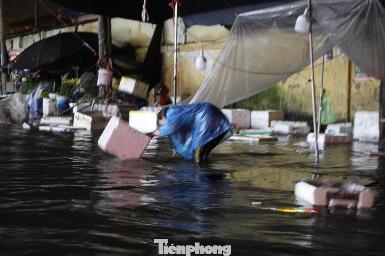 Nhiều thương lái xót của, nên bất chấp mưa lớn vẫn lấy rổ, rá để mò mẫm và vớt vát hoa, quả bị nước cuốn trôi.