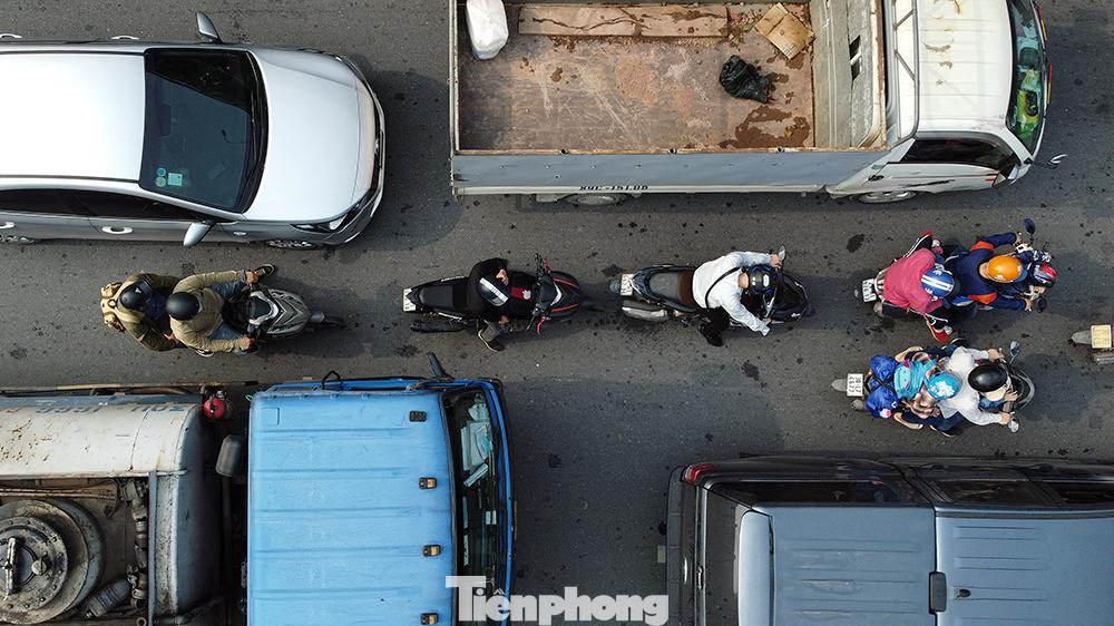 Xe máy bị "bao vây" bởi từng hàng ô tô dài bất tận.