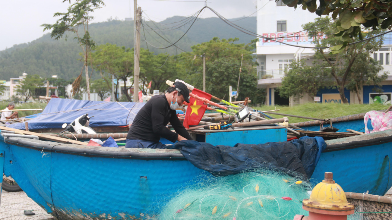 Một ngư dân gia cố lại phương tiện, ngư lưới cụ sau khi thuyền gắn máy được đưa lên bờ.