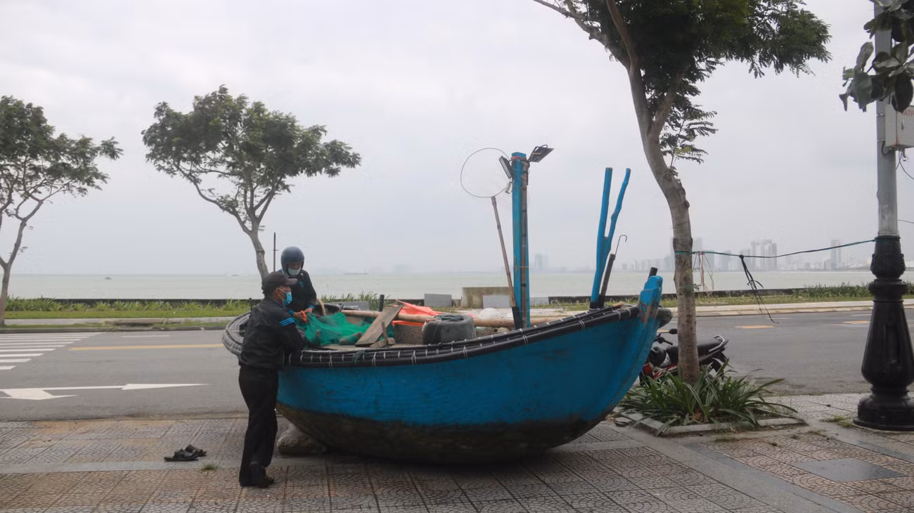 Một thuyền gắn máy được kéo lên vỉa hè đường Hoàng Sa để tránh bão.