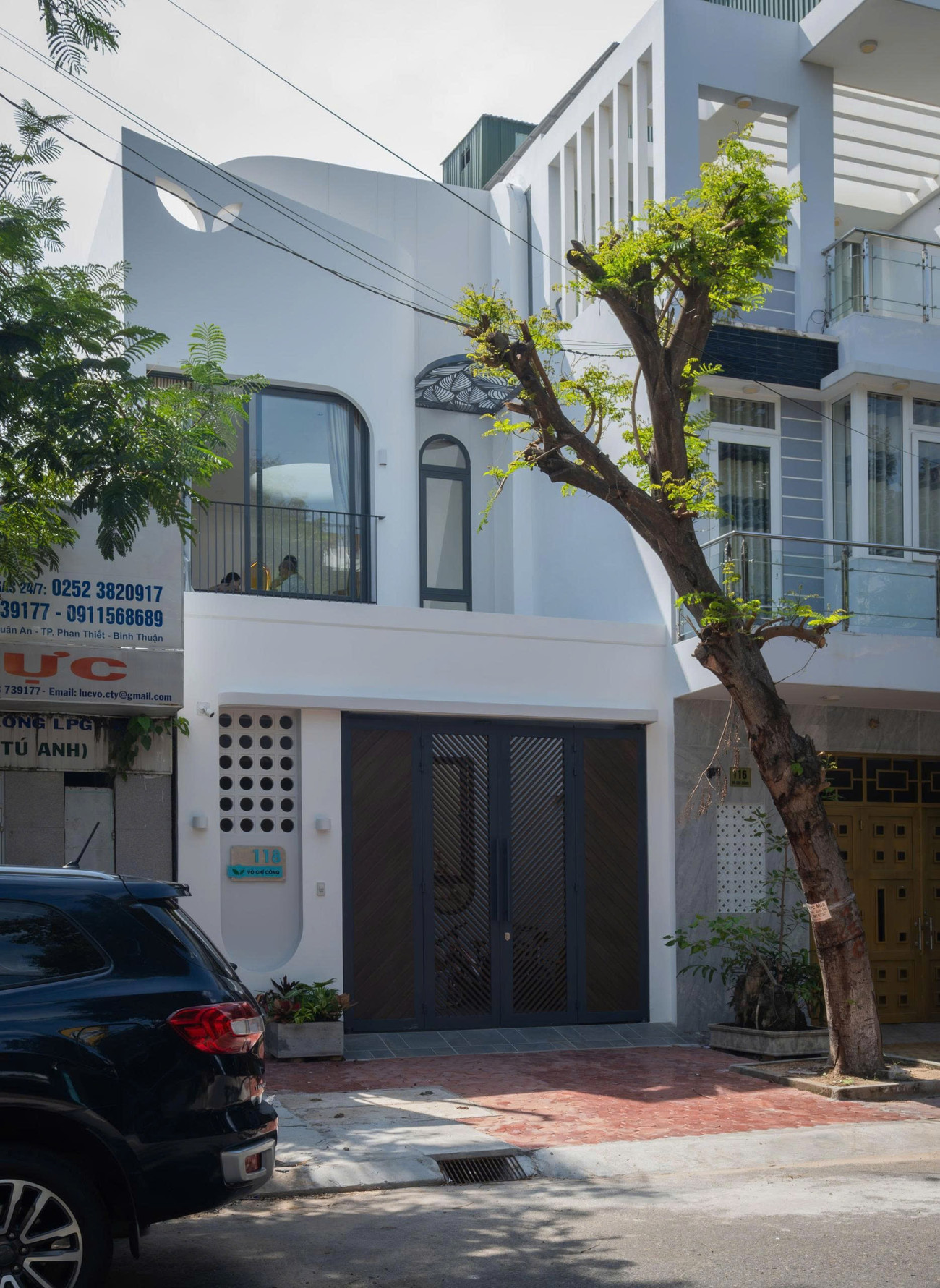 Kiến trúc sư đã tạo một đường cong mềm mại ở đỉnh và khoét hai ô trống hình cánh hoa, tạo nên một nhận diện rất riêng và duyên dáng cho ngôi nhà.