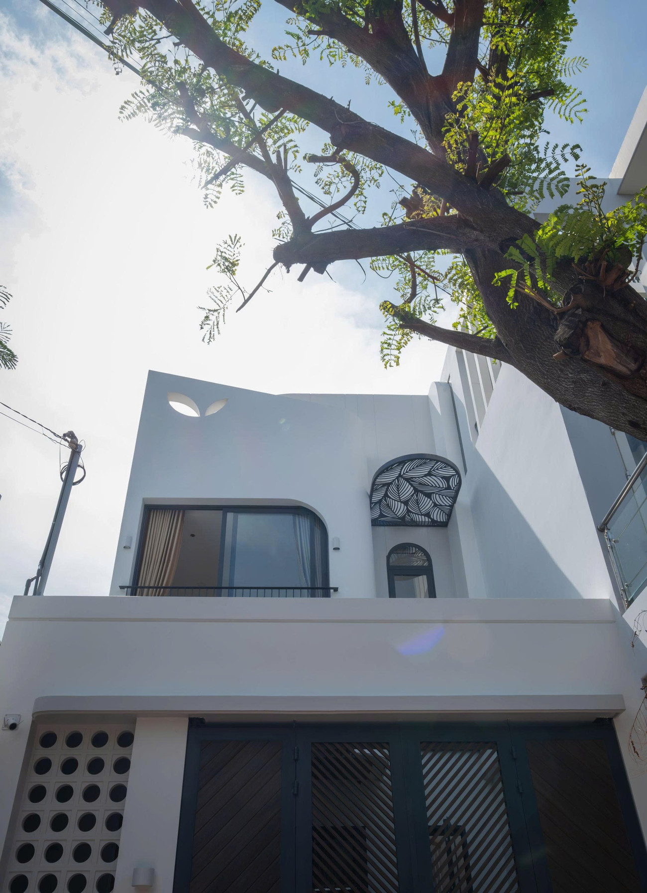 Mái che cong được trang trí bằng hoa sắt nghệ thuật hình chiếc lá đồng bộ xuyên suốt ý tưởng về công trình