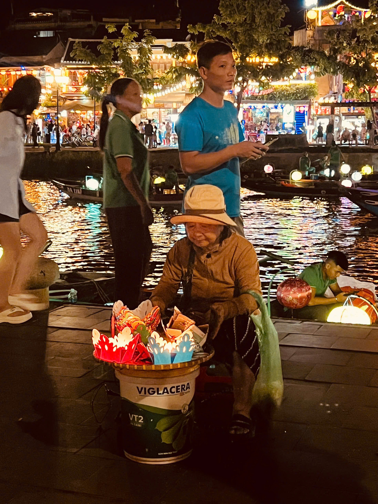 Những phụ nữ lớn tuổi bán hoa đăng bên sông Hoài. Ảnh: Văn Nhất 2 6838 2950