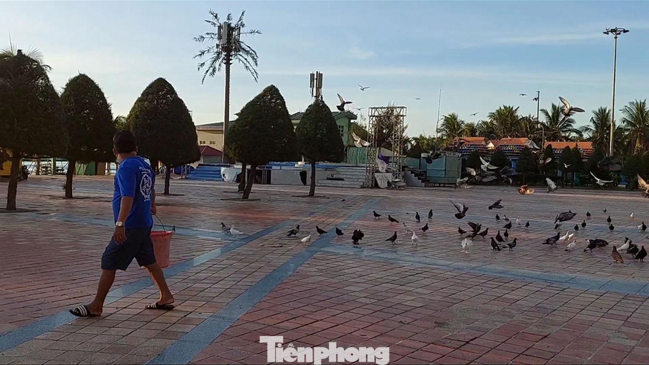 Cuối cùng anh Thanh phải đi về phía mấy chuồng chim vừa thổi còi và tìm cách dỗ chúng ra ăn sáng. Ảnh: Tr.T Cuối cùng anh Thanh phải đi về phía mấy chuồng chim vừa thổi còi và tìm cách dỗ chúng ra ăn sáng. Ảnh: Tr.T