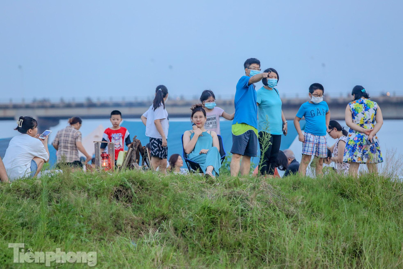 Một khu đất trống tại bãi giữa chân cầu Vĩnh Tuy tập trung đông người trong đó nhiều người không đeo khẩu trang, giãn cách với người xung quanh.