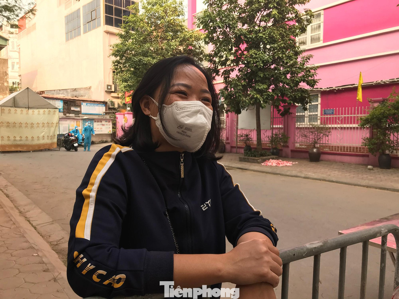Chị Nguyễn Thị Bích Liên trao đổi với phóng viên Tiền Phong qua rào chắn khu thu dung điều trị cách ly F0 thể nhẹ đặt ở trường mầm non phường Giáp Bát. Ảnh: Trường Phong