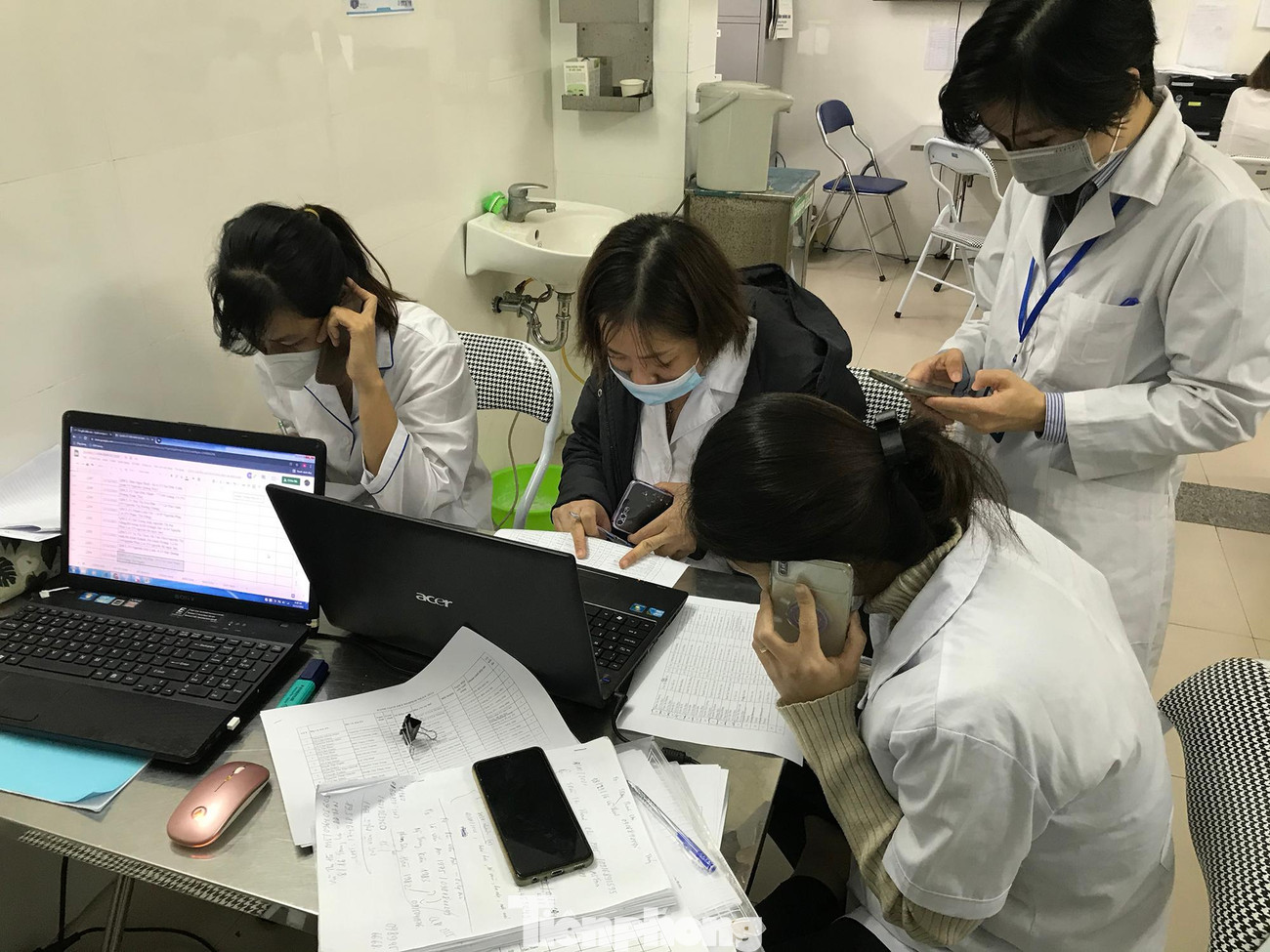 Nhân viên Trạm y tế phường Ô Chợ Dừa ‘cháy máy’ điện thoại tư vấn, chăm sóc, điều tra, truy vết các trường hợp liên quan COVID-19 trên địa bàn phường. Ảnh: Trường Phong