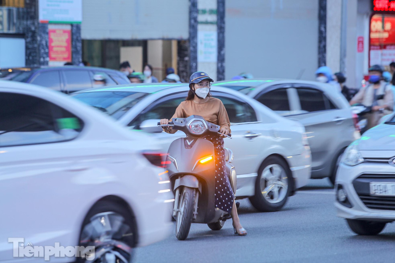 Xe máy loay hoay giữa các làn xe ô tô.