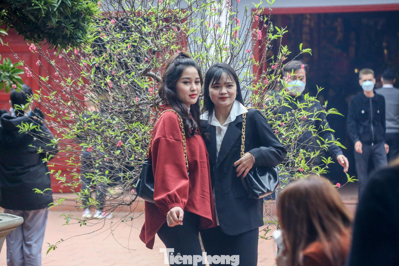 Một số người bỏ khẩu trang để chụp ảnh tại sân phủ Tây Hồ.