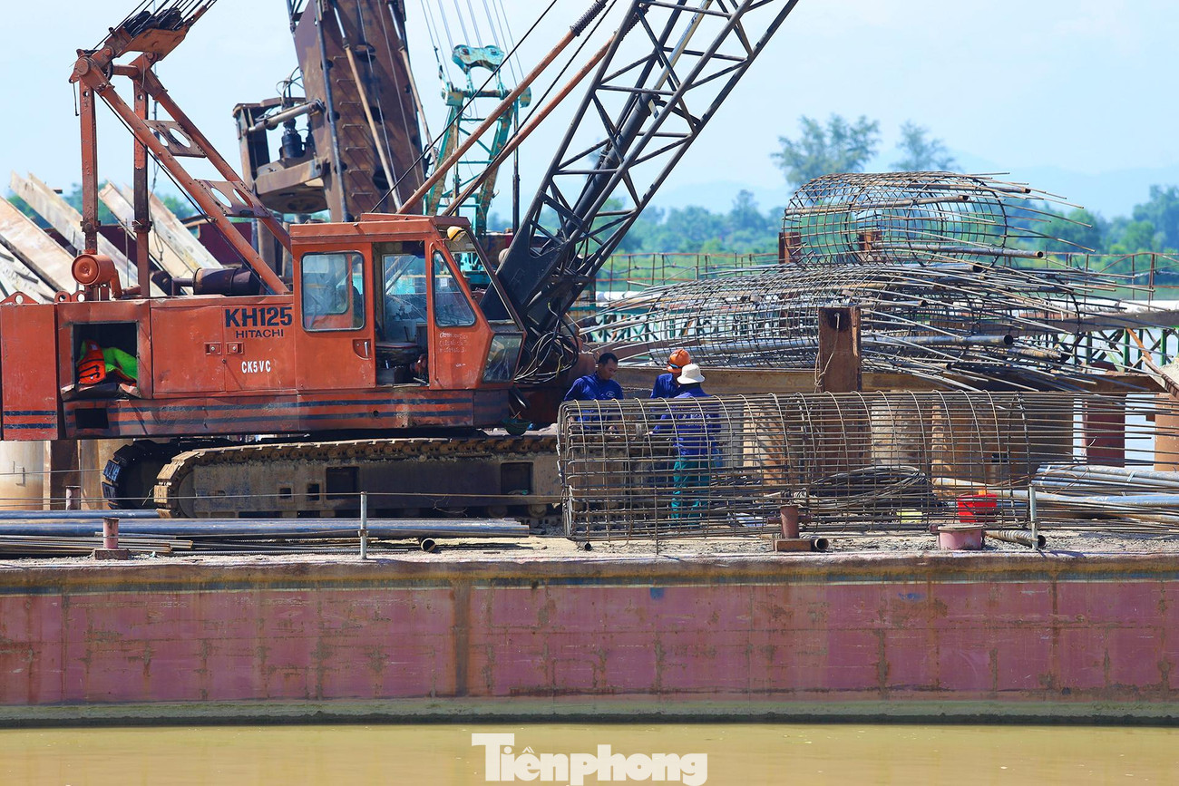 Trên các sà lan cỡ lớn, cọc nhồi, kết cấu thép để đặt các trụ bê tông cho từng nhịp cầu giữa sông được từng nhóm công nhân gấp rút hoàn thiện.
