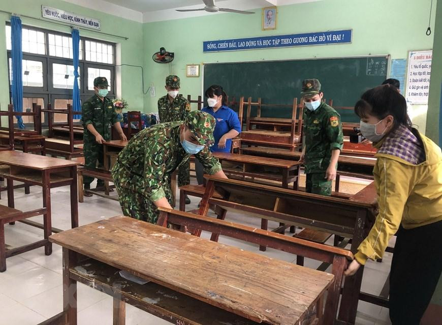 Cán bộ, chiến sỹ Đồn Biên phòng cửa khẩu cảng Quy Nhơn phối hợp với chính quyền địa phương giúp Trường Mầm non Nhơn Bình (thành phố Quy Nhơn) dọn dẹp vệ sinh, khắc phục hậu quả lũ lụt. (Ảnh: Nguyên Linh/TTXVN)