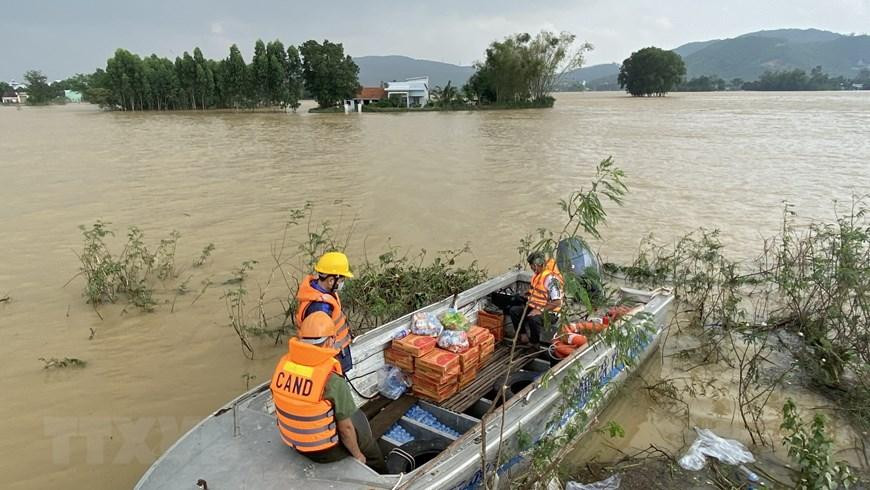 Công an huyện Tuy Phước, tỉnh Bình Định, dùng ca-nô chở nhu yếu phẩm qua cho người dân vùng lũ xã Phước Nghĩa. (Ảnh: Tường Quân/TTXVN)