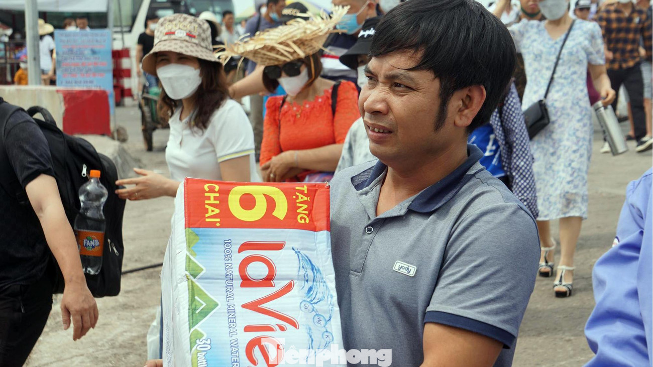Một du khách mang theo nước, đồ ăn sang đảo Cát Bà cho cả nhóm sử dụng.