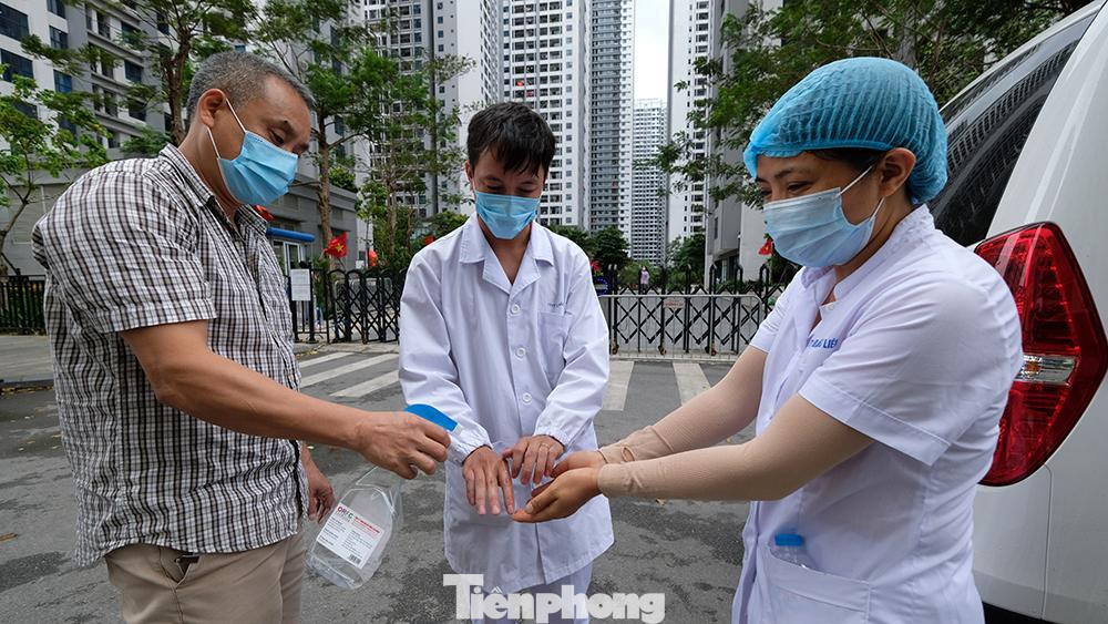 Nhân viên y tế sát khuẩn tay sau khi đưa mẫu bệnh phẩm lên xe chuyên dụng.