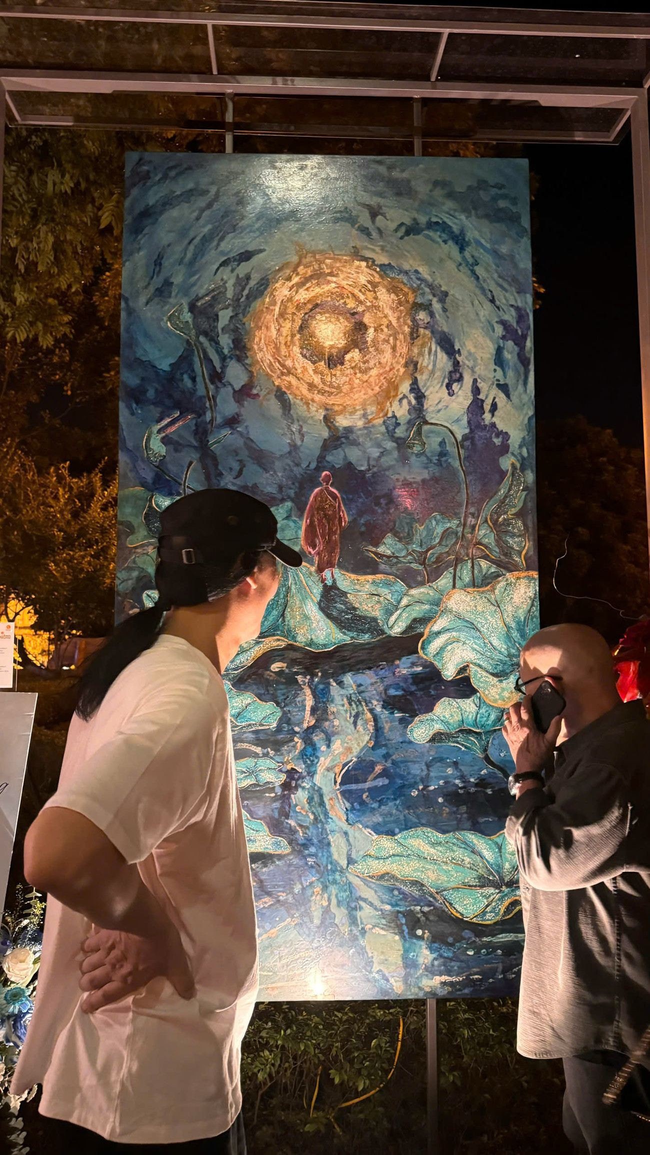 NSƯT Chu Lượng, nguyên Giám đốc Nhà hát Múa rối nước Thăng Long, cha của họa sĩ Chu Nhật Quang cùng họa sĩ Thành Chương ngắm tác phẩm.