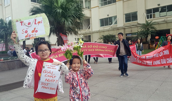 Lẽ ra, cuối tuần chị Trang đưa hai con đi công viên chơi, nhưng cực chẳng đã chị phải đưa hai cháu xuống đường đòi quyền lợi cùng. Ảnh: Ninh Phan. Dân chung cư 'dát vàng' lại xuống đường căng băng rôn đòi sổ đỏ ảnh 5