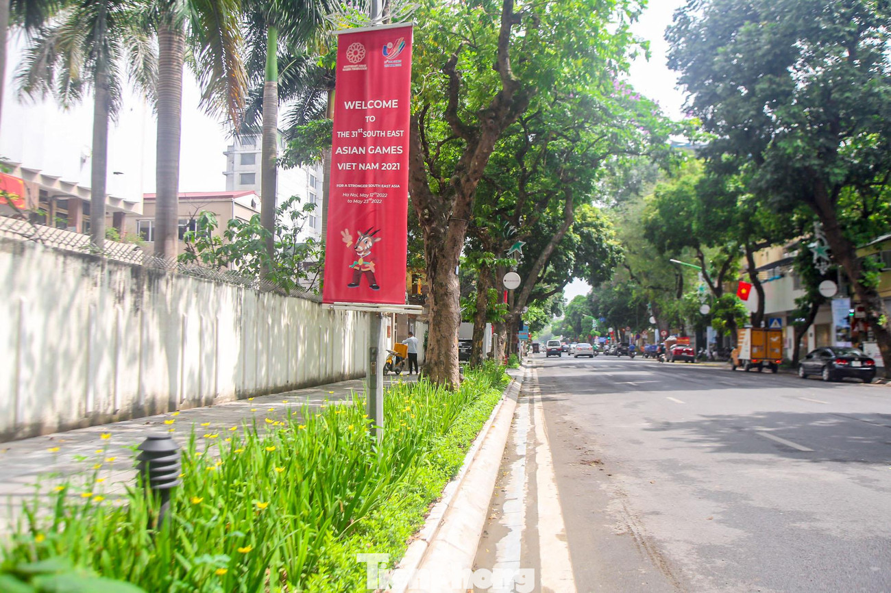 Thảm cỏ xanh mướt bên cạnh pano cổ vũ SEA Games 31 trên phố Hàng Bài.