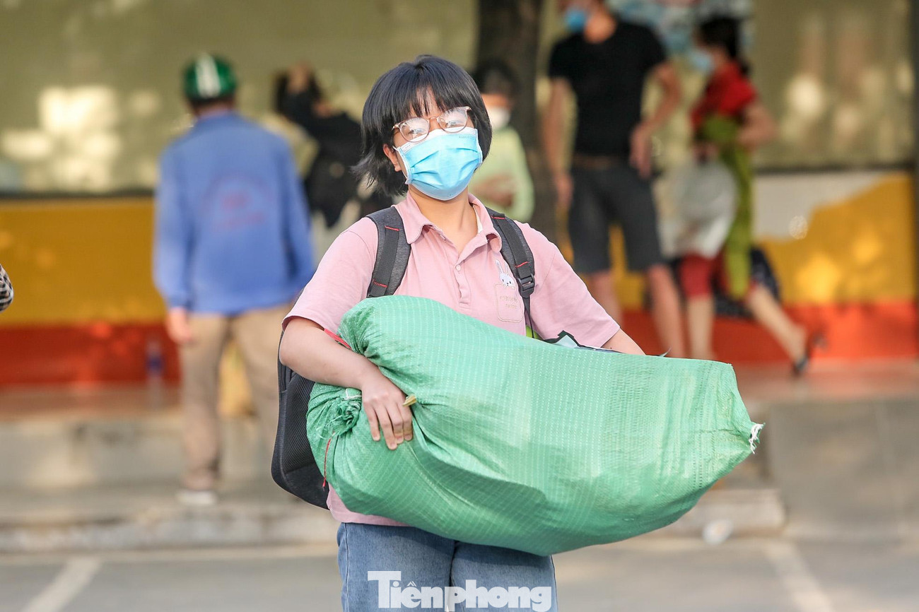 Một người phụ nữ vác cả bao tải đồ.