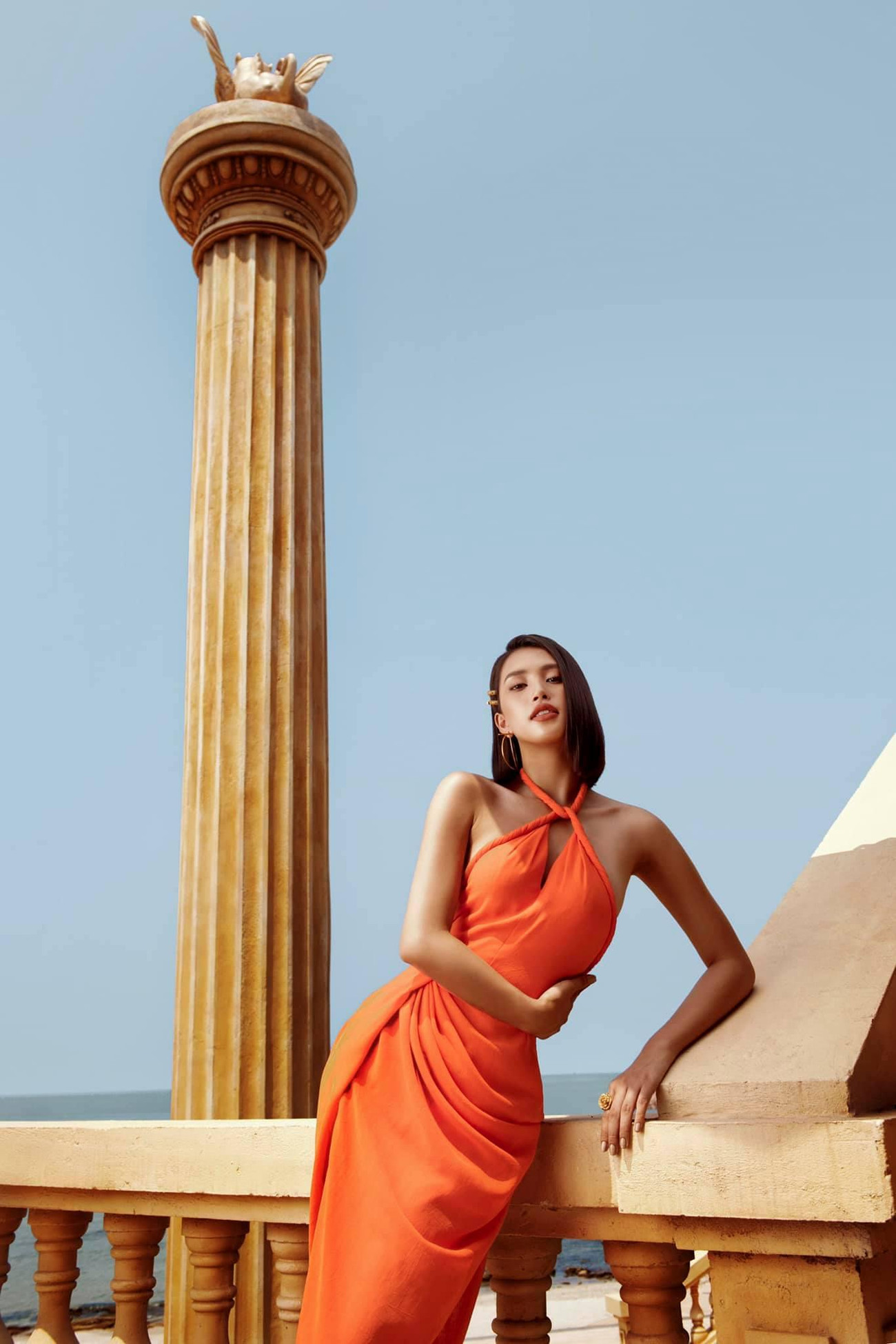 Kiểu váy cổ yếm tông màu cam cùng những đường cắt xẻ tinh tế khiến Tiểu Vy đẹp như một 'nữ thần' đầy quyến rũ.