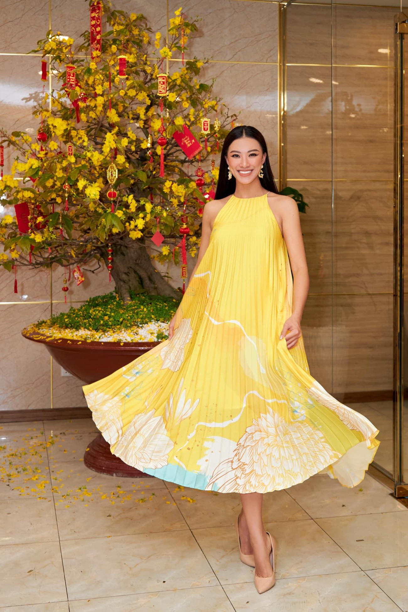 Á hậu Kim Duyên đẹp rực rỡ như một nàng Xuân kiêu kỳ khi diện váy yếm tông màu vàng nổi bật, được xử lý kiểu xếp ly tinh tế.
