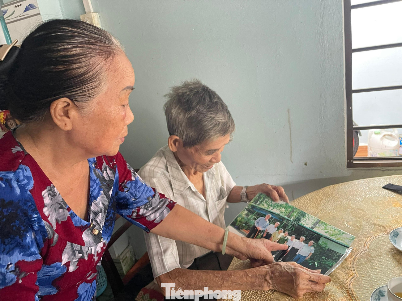 Ông Nguyễn Xuân Viên cùng vợ, bà Nguyễn Thị Tư xem lại ảnh tư liệu chụp lại lần các cựu tù Côn Đảo gặp nhau. Ảnh: Trọng Tài Ông Nguyễn Xuân Viên cùng vợ, bà Nguyễn Thị Tư xem lại ảnh tư liệu chụp lại lần các cựu tù Côn Đảo gặp nhau. Ảnh: Trọng Tài
