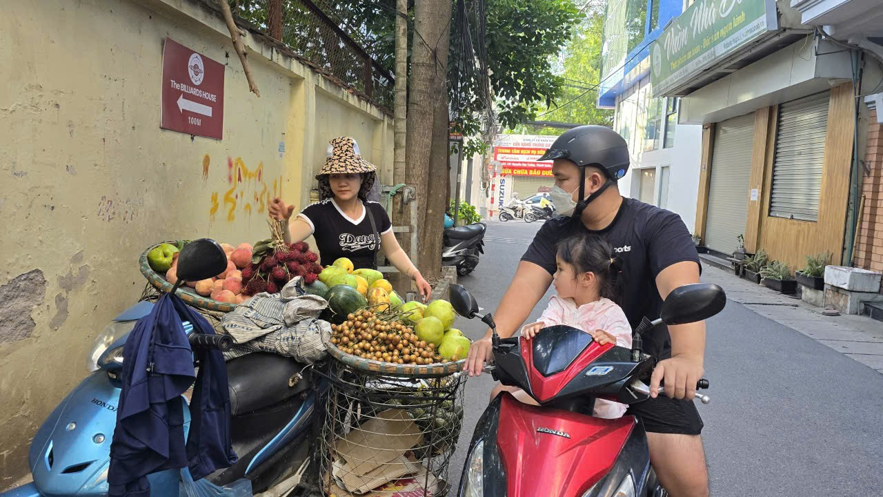Chị Vũ Thị Ngọc (30 tuổi) rong ruổi xe hàng trên chiếc xe máy cũ khắp phố Hà Nội để bán hàng, mong muốn sẽ có chế độ hỗ trợ khi triển khai cấm xe máy chạy xăng hoạt động trong Vành đai 1. Ảnh: Trọng Đảng.