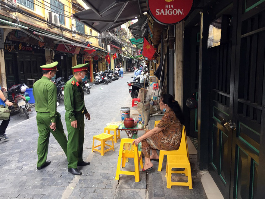 Công an quận Hoàn Kiếm tuần tra, nhắc nhở người dân thực hiện công tác phòng chống dịch COVID-19.