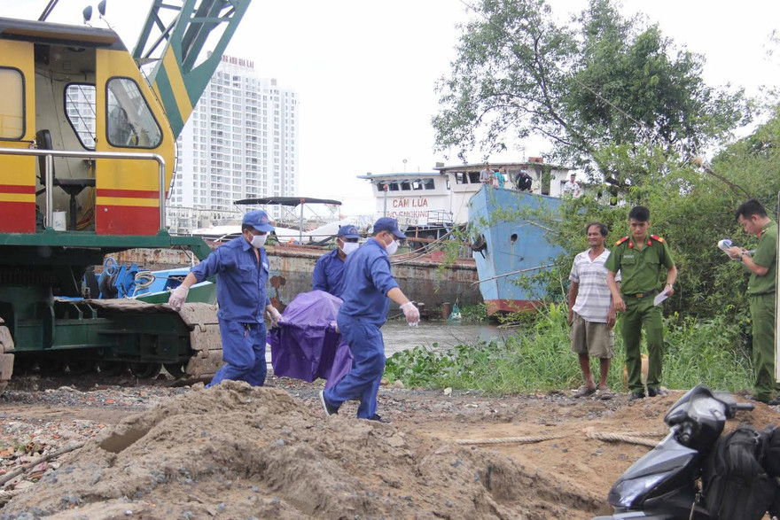 Lực lượng chức năng đưa thi thể nạn nhân lên bờ.