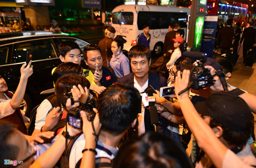 HLV Hữu Thắng trong vòng vây báo chí ở sân bay Tân Sơn Nhất tối nay.