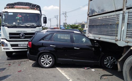 Ôtô 7 chỗ nát bươm, kẹt cứng giữa 2 xe tải. 