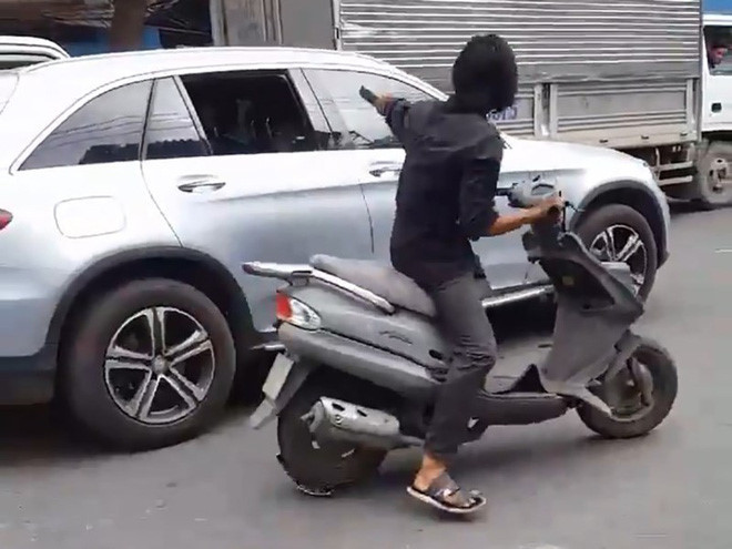 Nam thanh niên ngang nhiên dùng mã tấu chém vỡ kính chiếu hậu của hàng chục xe ô tô đang chạy trên đường tại TP.HCM. Ảnh cắp từ clip
