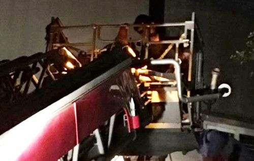 Nhà chức trách điều động xe thang đến đưa thi thể nạn nhân ra ngoài. 