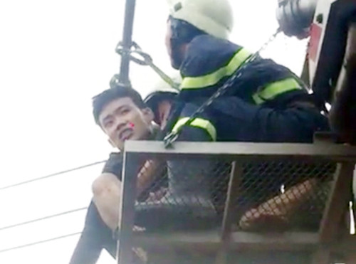 Thành được cảnh sát đưa xuống bằng xe thang. 