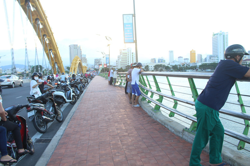 Người dân tập trung trên cầu Rồng để theo dõi việc tìm kiếm nạn nhân. 