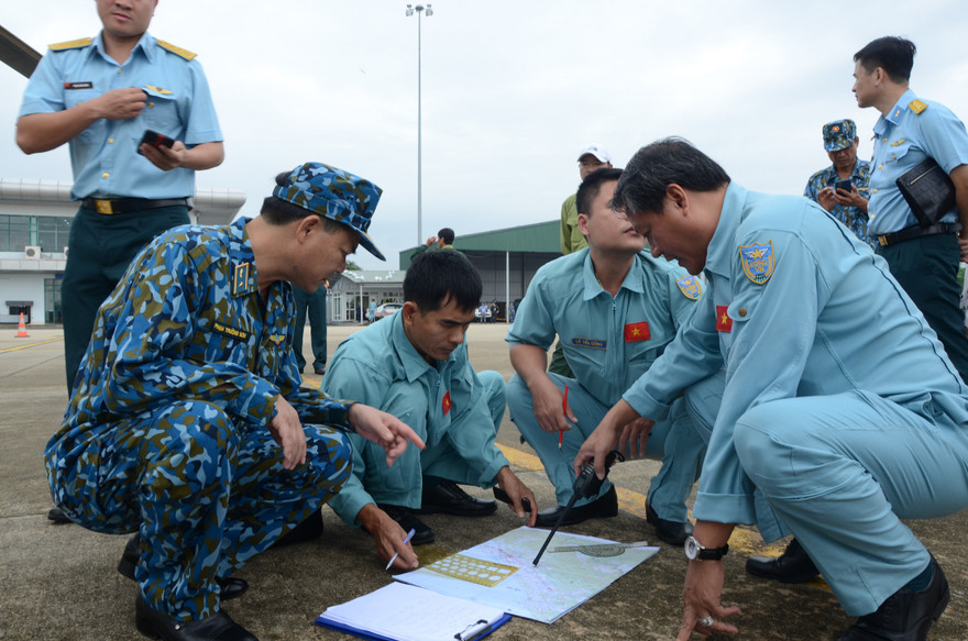 Thiếu tướng Phạm Trường Sơn (người ngồi bên phải) - Phó Tư lệnh Quân chủng Phòng không - Không quân trao đổi phương án cứu hộ với tổ bay Trung đoàn 930. Ảnh: PK-KQ