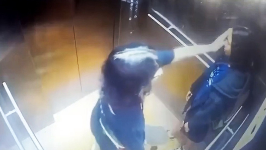 Hai cô gái cầm ván trượt patin đi từ ngoài chung cư vào thang máy.