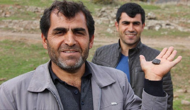 Một người đàn ông khoe viên "đá trời" màu đen quý hiếm ông nhặt được.