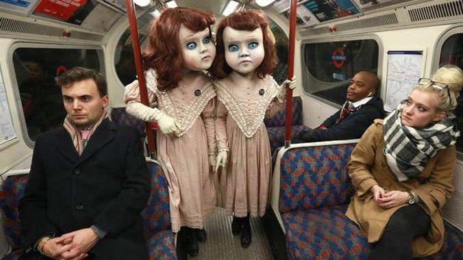 Mặc dù ga tàu điện chật kín người, sự xuất hiện của đôi búp bê song sinh to lớn như người thật vẫn làm những ai nhìn thấy nổi cả da gà.