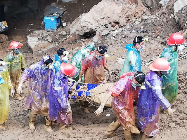 Thi thể phu vàng được lực lượng chức năng đưa ra ngoài. Ảnh: Dân trí