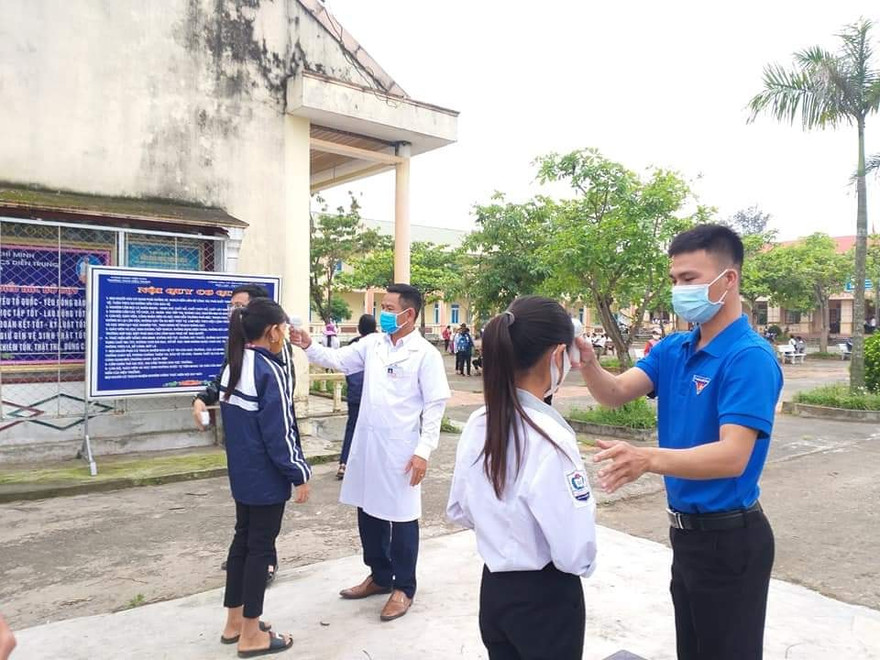 Học sinh được đo thân nhiệt trước khi vào lớp học.