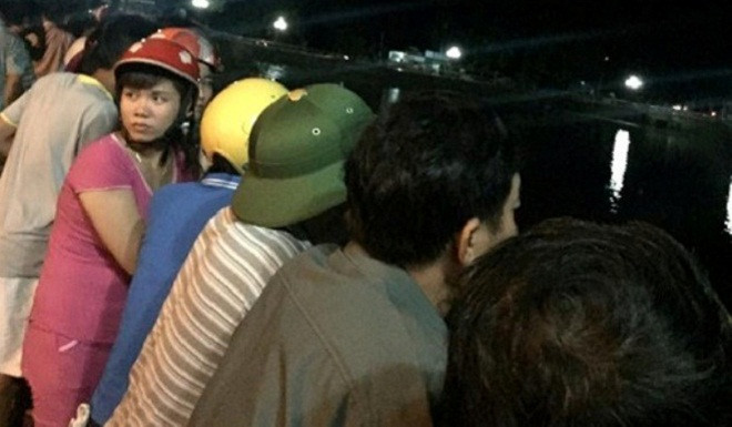 Hàng trăm người đứng trền bờ theo dõi lực lượng cứu hộ tìm kiếm nạn nhân Sơn. Ảnh: N.T.