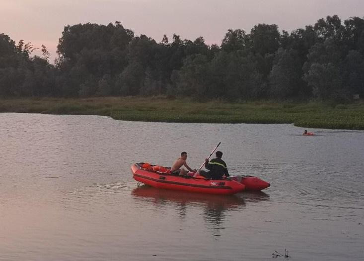 Lực lượng cứu hộ đang chèo xuồng hơi tìm người mất tích. Ảnh: Nguyễn Long.